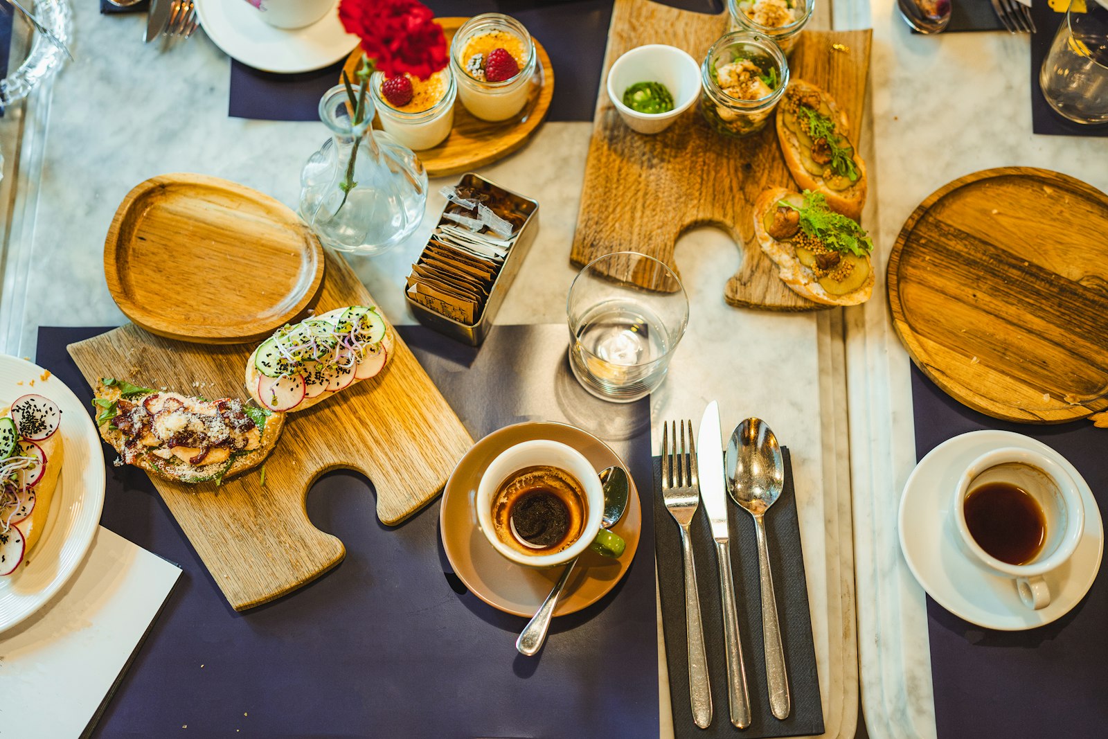 Frühstückstisch mit belegten Broten und Kaffee.